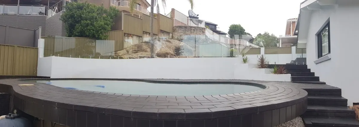 Glass pool fencing installed by Coastal Glaziers around a backyard pool