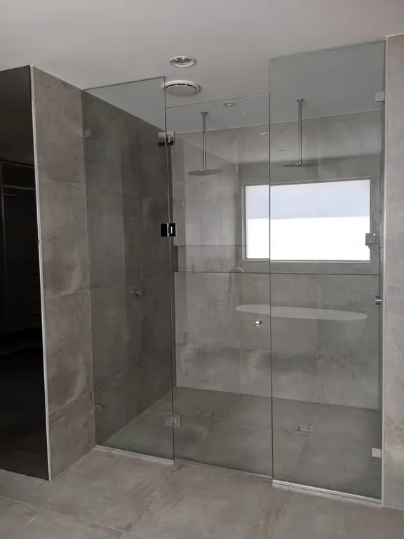 Frameless glass shower screen in a clean, modern bathroom